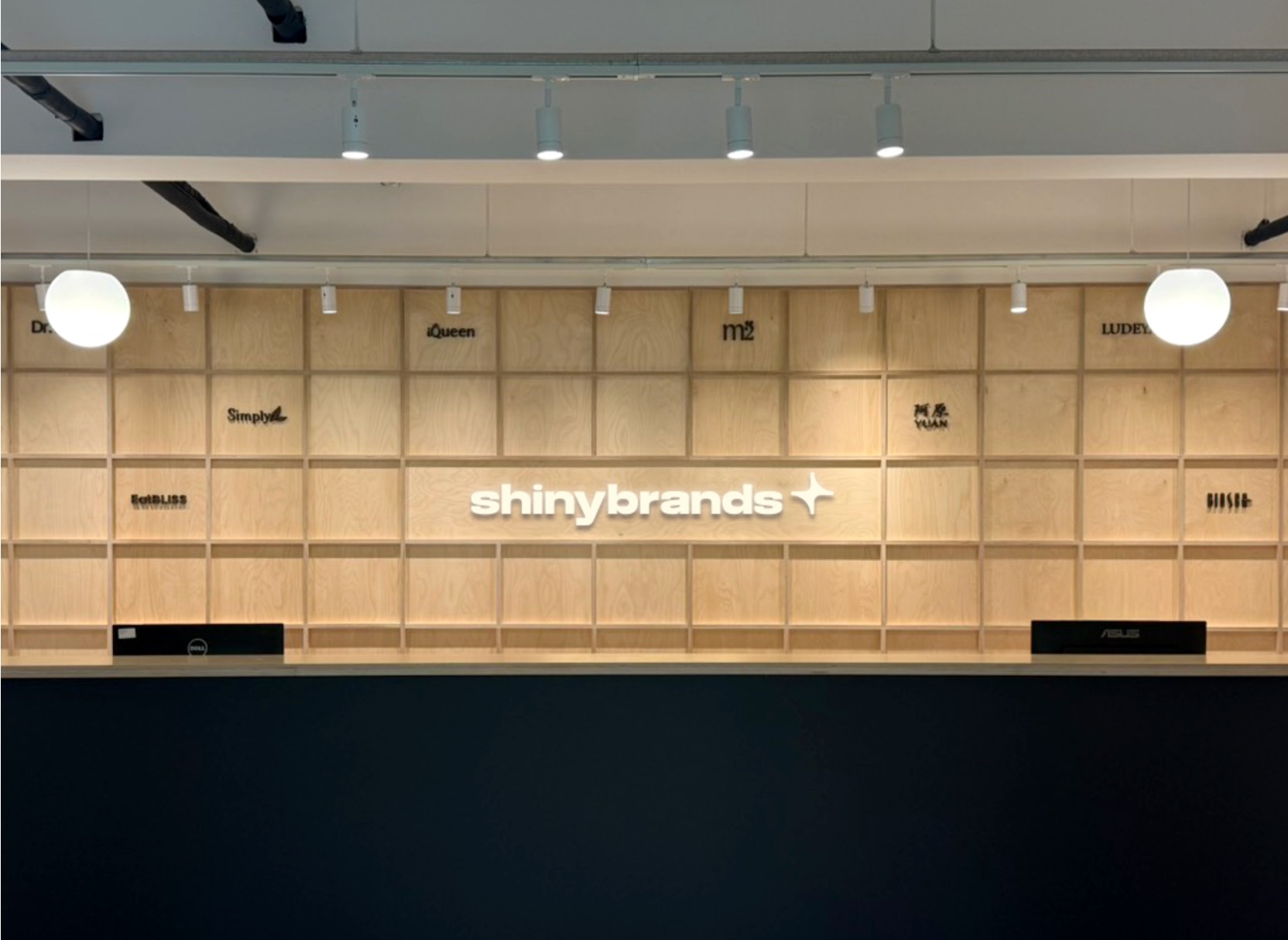 Shinybrands logo on the wooden grid wall of a reception area