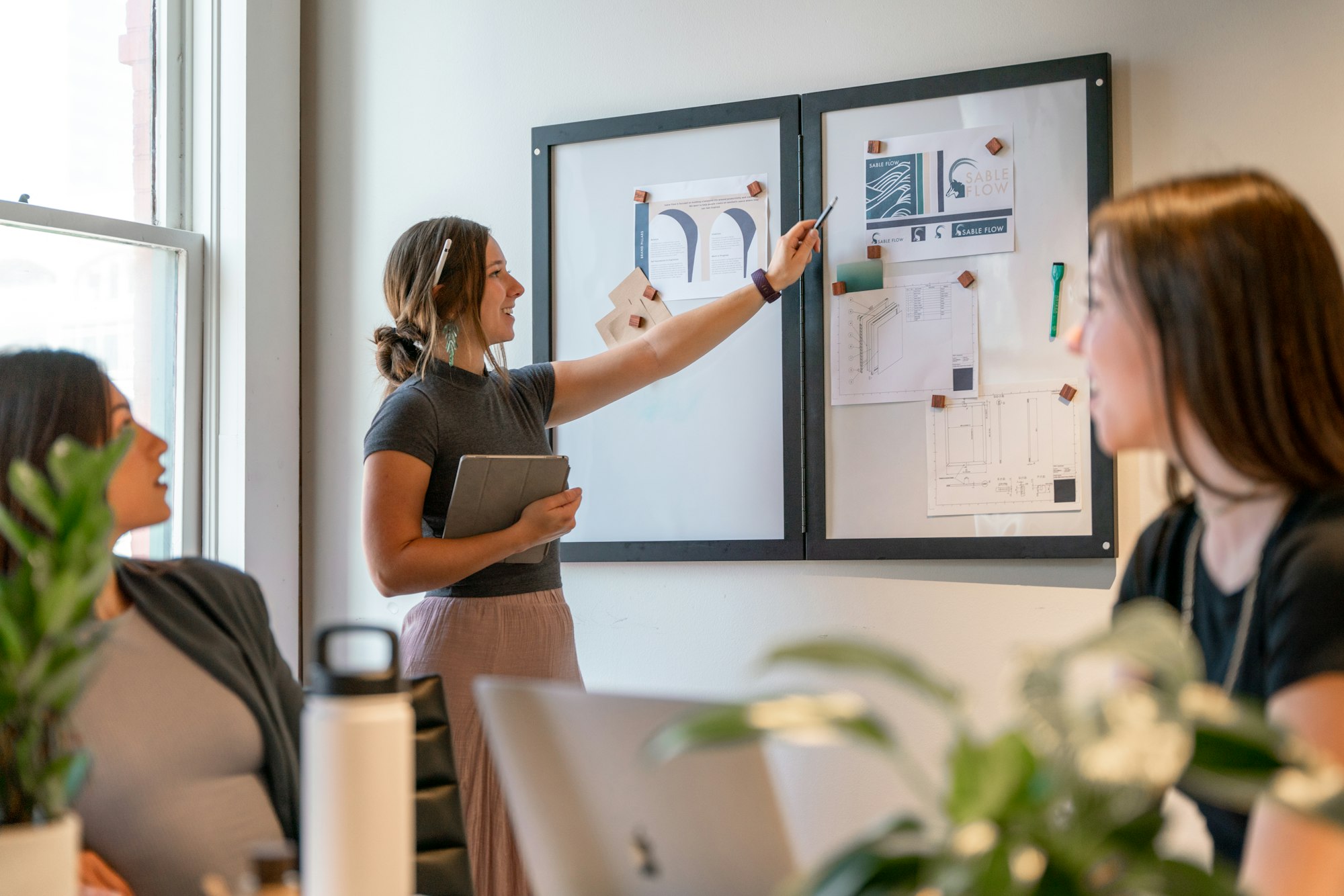 Team reviewing materials on a wall board in an office