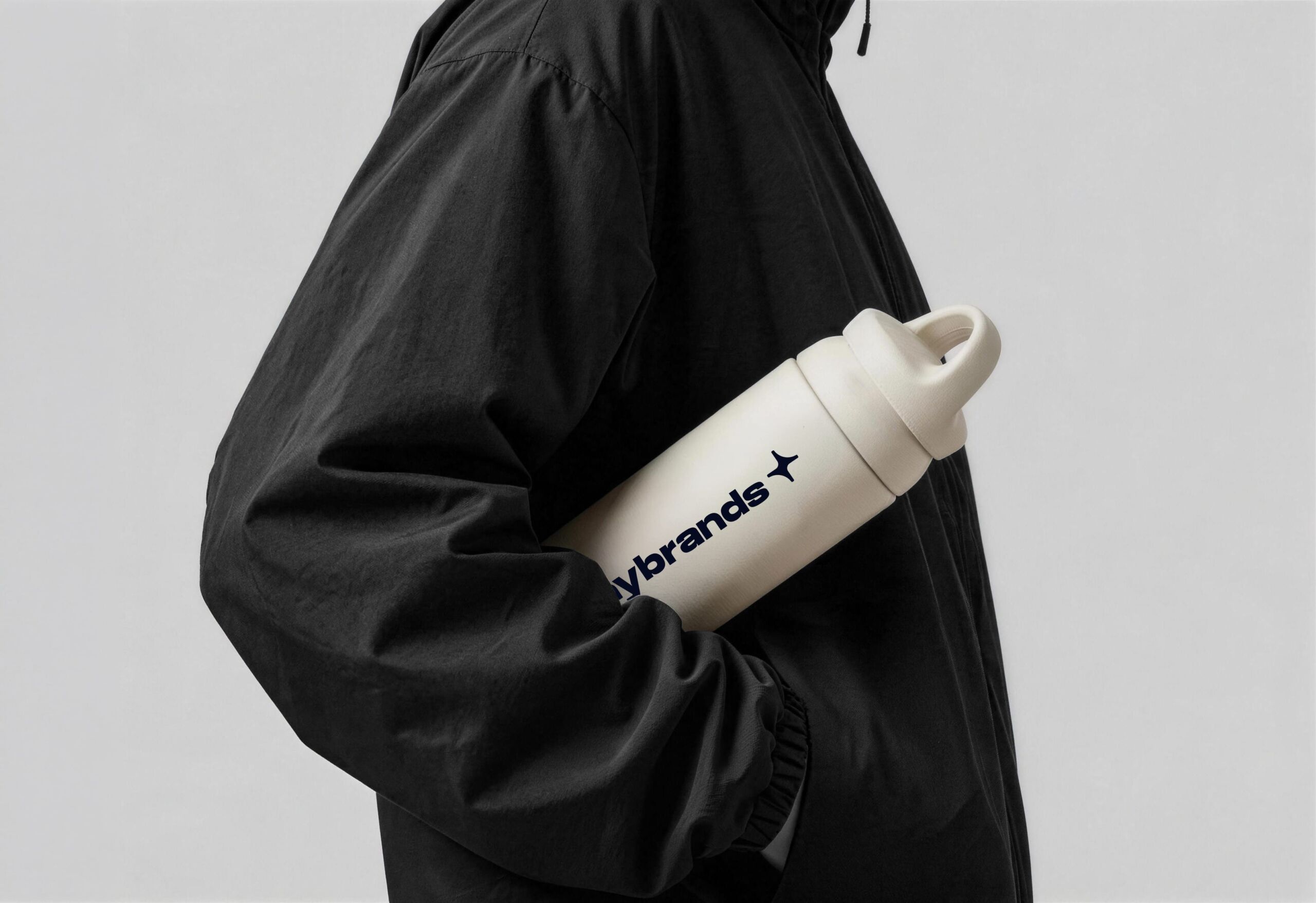Person carrying a white bottle printed with the Shinybrands logo