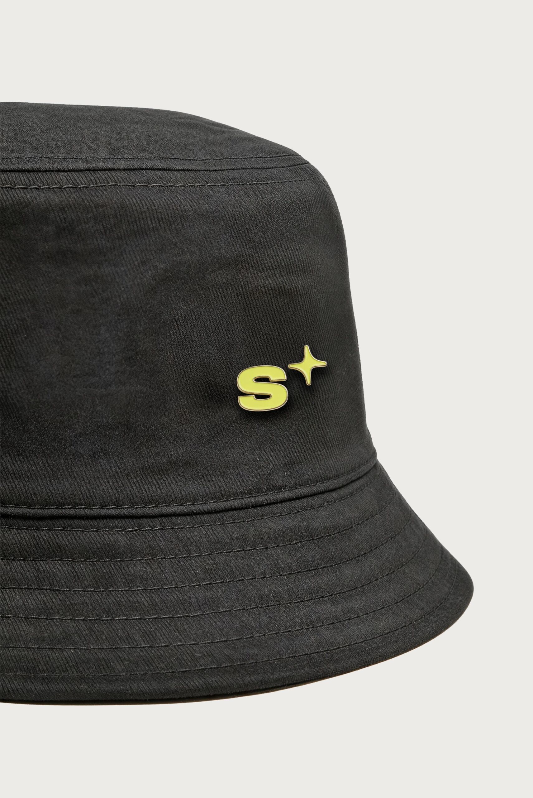 Black bucket hat with a yellow S+ badge