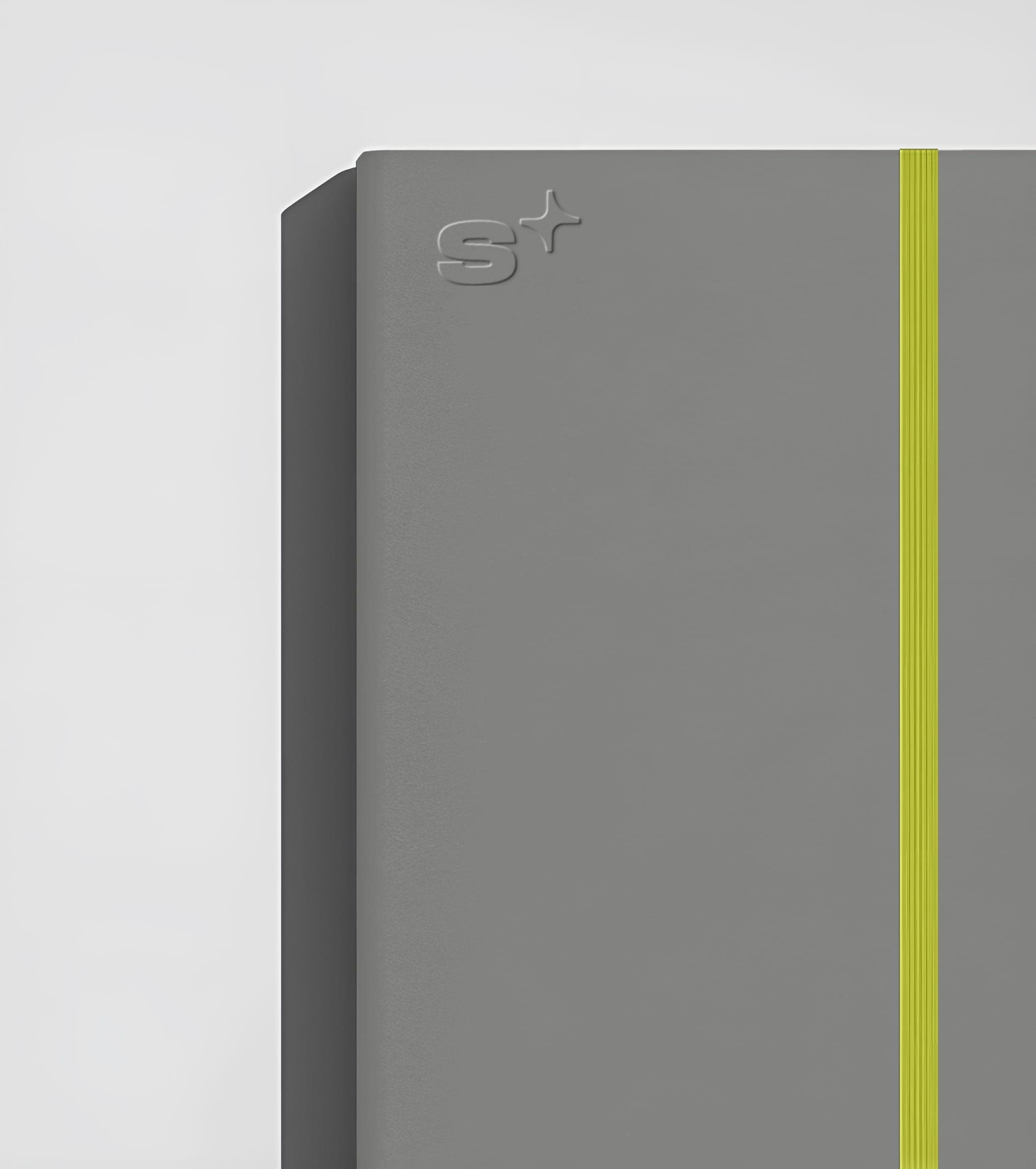 Gray notebook cover with the S+ symbol and a lime accent strip